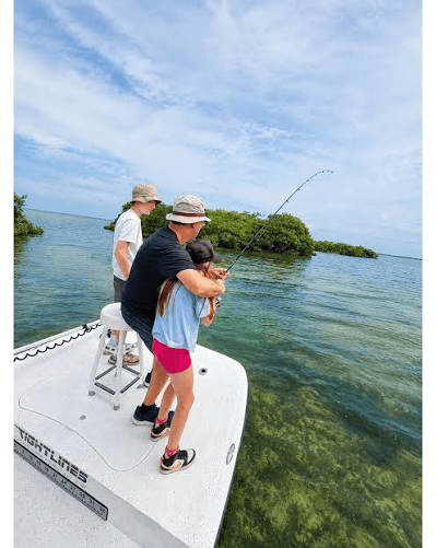 Family fishing in shallow Florida Keys water near mangroves.